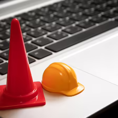 Traffic cone and hardhat on a laptop keyboard