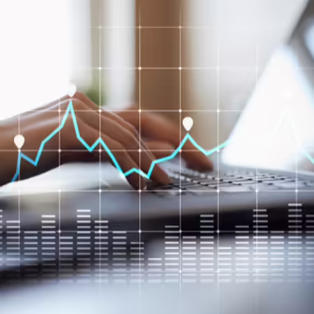 graph superimposed over hands on keyboard
