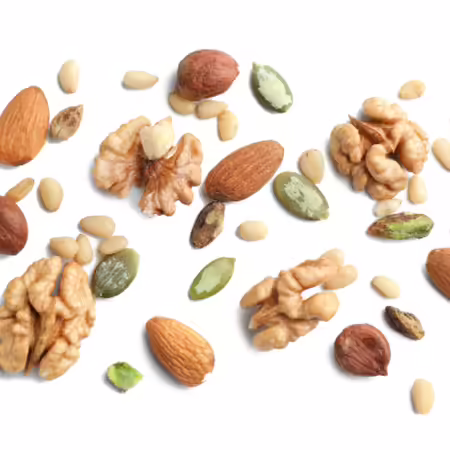 Repeating pattern of walnuts, pumpkin seeds, pine nuts, almonds, and macadamia nuts