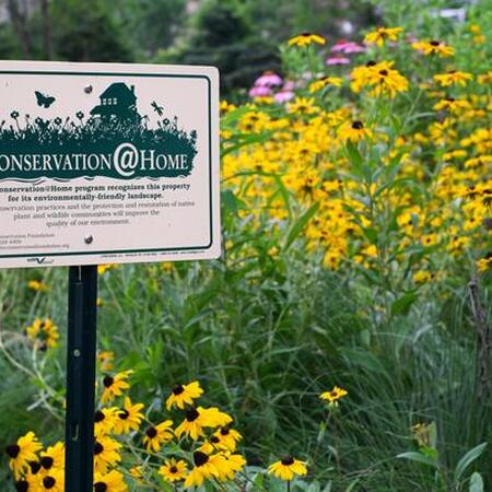 Conservation at Home sign in a flower garden