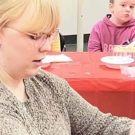 Young woman piping frosting on a cupcake
