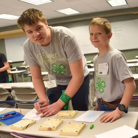 4-H teen standing with younger 4-H youth