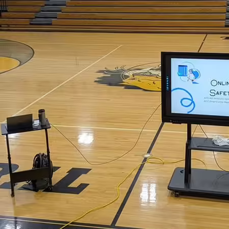 Picture of a presentation screen on a school gymnasium floor