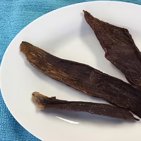 3 strips of venison (deer) jerky on white plate