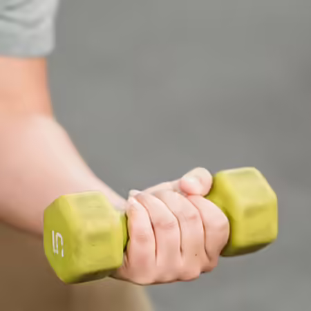 Person performing a concentration bicep curl with a dumbbell