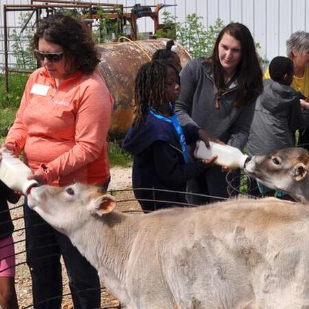 Extension Educator with students at a farm with animals