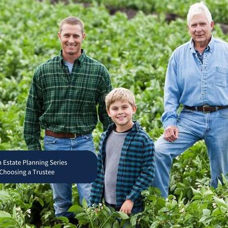 three generations of farmers standing in a field of crops