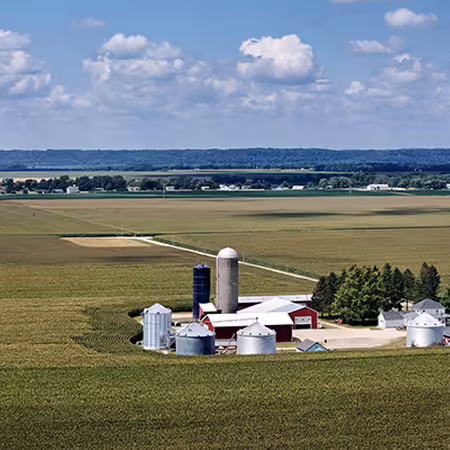 A farm with buildings surrounded by crop fields.