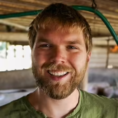 Max Allbritten smiles in his pig barn 