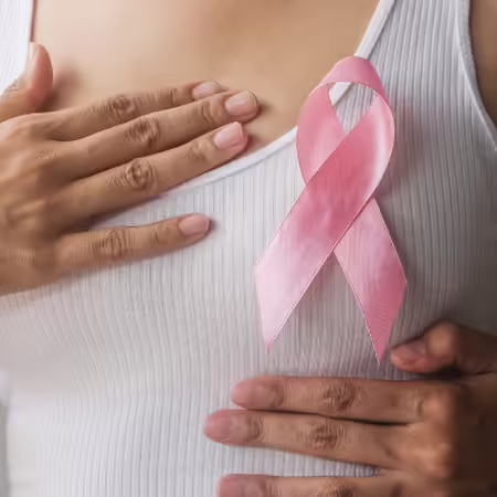 non identifiable woman wearing white tank and pink ribbon 