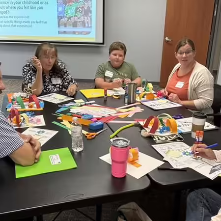 People talking to each other while sitting around a table