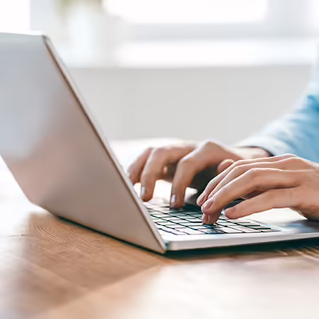 hands typing on a laptop