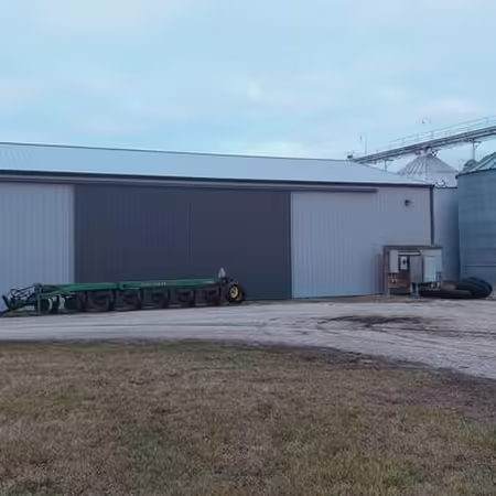 Pole barn with piece of machinery in front