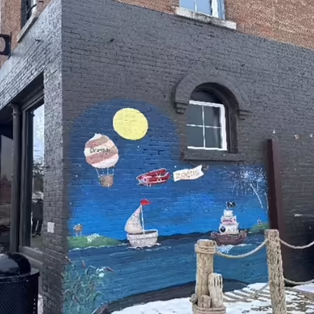 storefront on corner of block with mural on wall