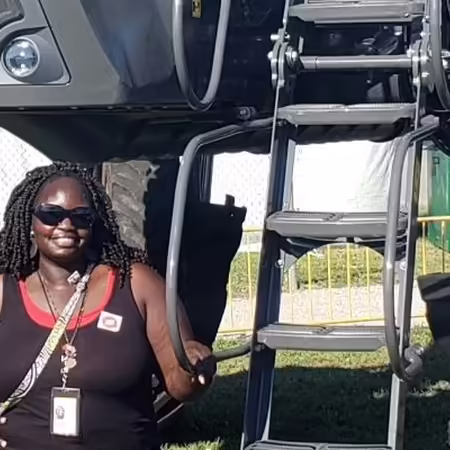 ISP Scholar Susan Ogwal in front of tractor at farm progress show