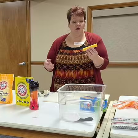 Woman speaking in front of a demonstration table