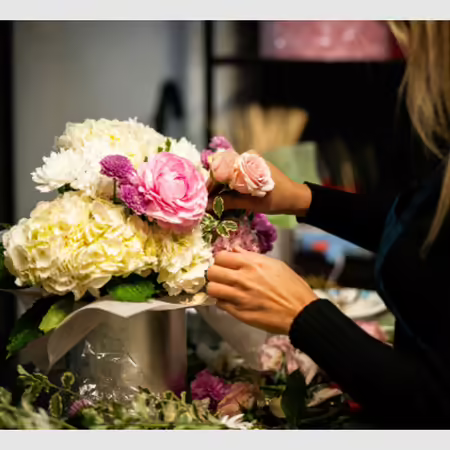 woman arranging floral bouquet