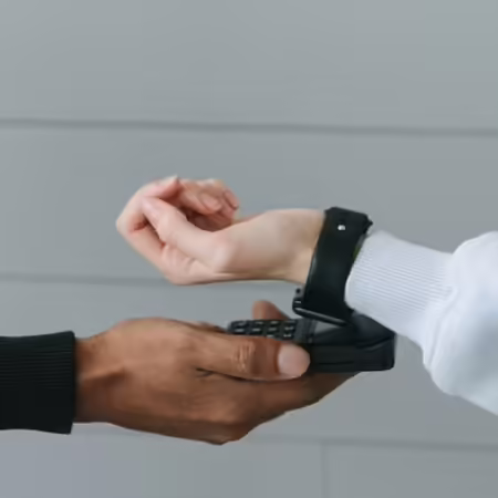 person holding phone while another person holds watch face to phone