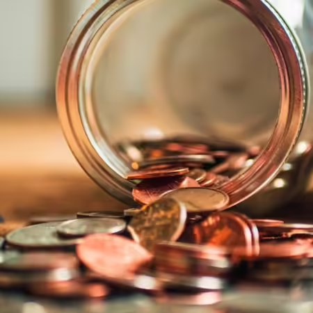 mason jar full of coins that spilled over onto carpet