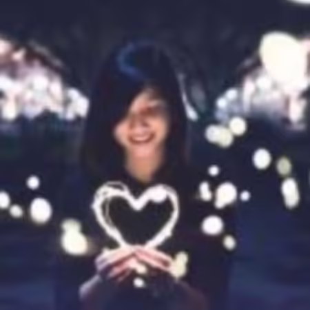 Woman holding a heart made of white light