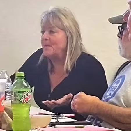 People sitting at a table with one person speaking