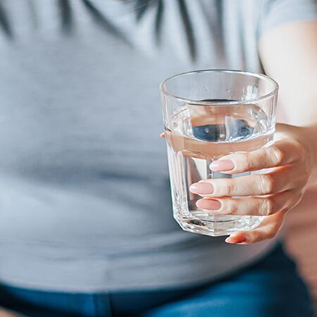 Person holding a glass filled with water