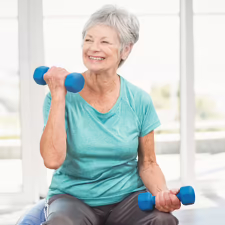 An older woman performs a dumbbell bicep curl exercise