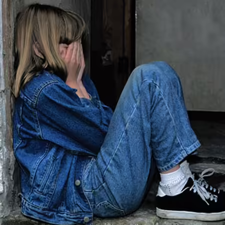 Child sits appearing sad.
