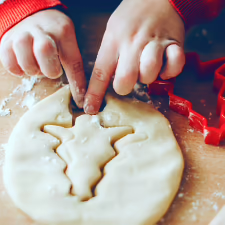 child making a christmas tree shaped cookie
