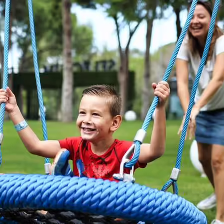 child being pushed on swing