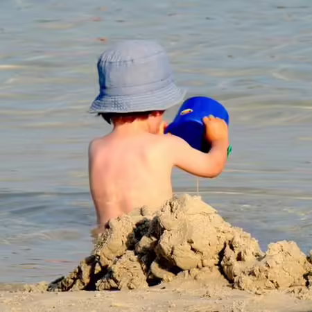 Little boy playing in sand on the beach
