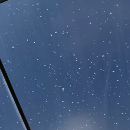 Hundreds of white dimples on clear plastic stretched over a high tunnel caused by the impact of hail.