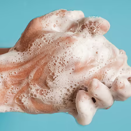 person rubbing soapy hands together