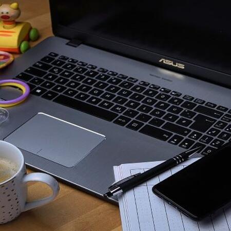 open laptop computer with a cup of coffee and baby toys