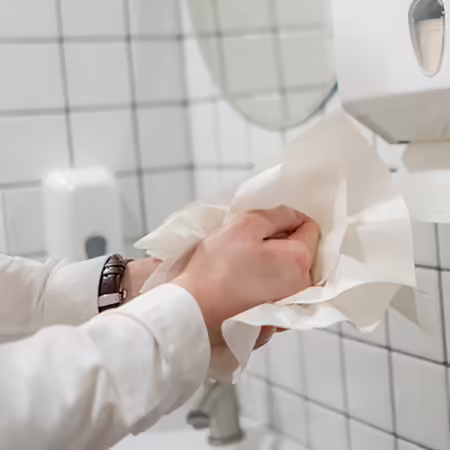 person drying hands with a paper towel