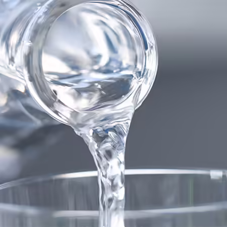 A clear liquid being poured into a glass