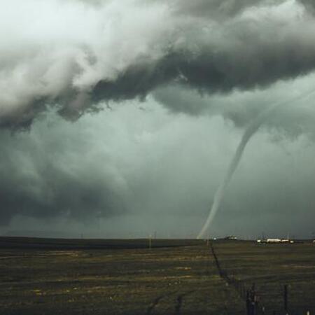 a tornado off in the distance surrounded by dark gray clouds 
