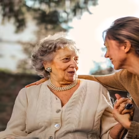 Two people talking and holding hands