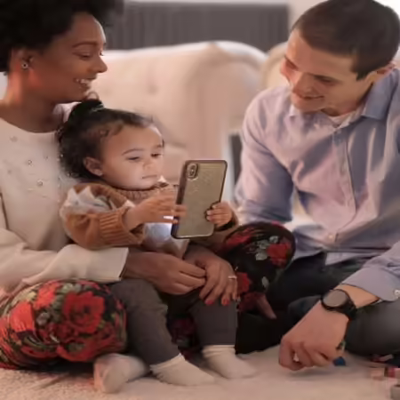 Man, woman and child playing on phone