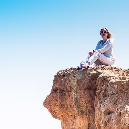woman sitting on cliff top