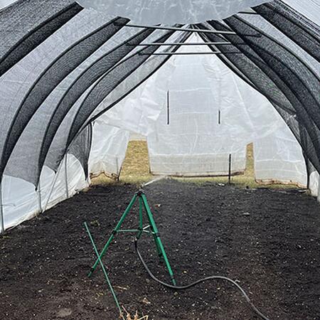 a greenhouse with a black net covering