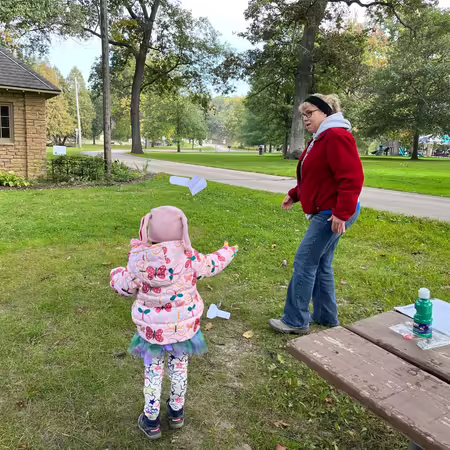 4-H and Youth Development Educator Kelly Lafferty flies a paper airplane with a Wee Nats participant