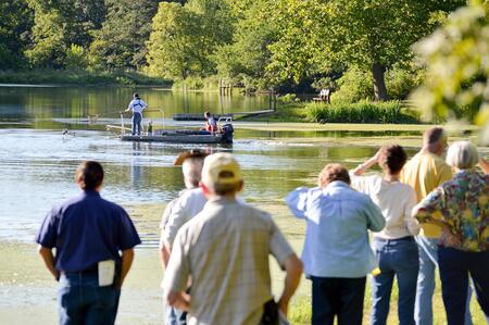 Crowd watches pond management in action during training.