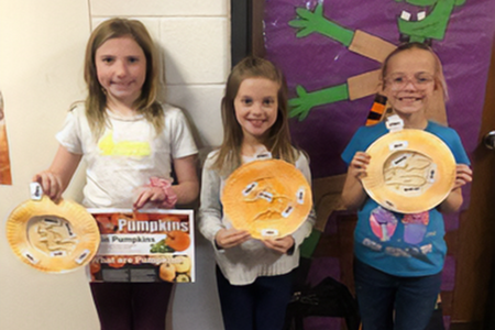 kids holding crafts of ag products