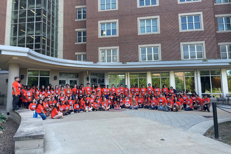 participants in a group shot in orange shirts