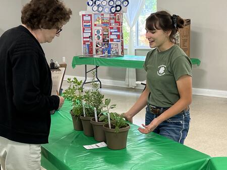 girl speaking to a judge with her herb project