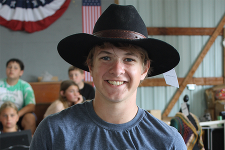 Boy in black cowboy hat and blue shirt