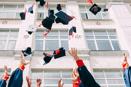 hands tossing graduation hats