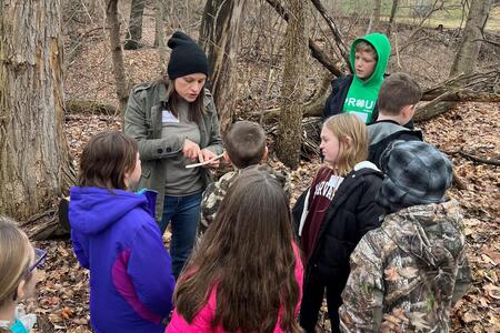 Amanda Atchley teaching a group of 4-H members in the woods