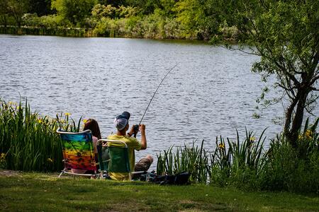 two people sitting in chairs fishing